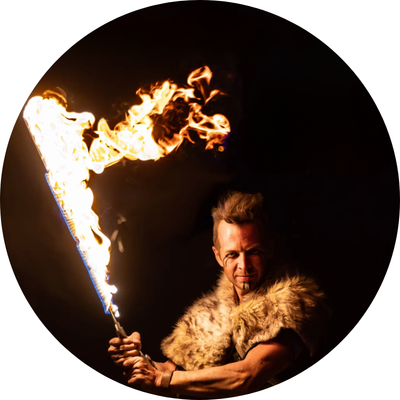 Performer at night holding a prop that's on fire